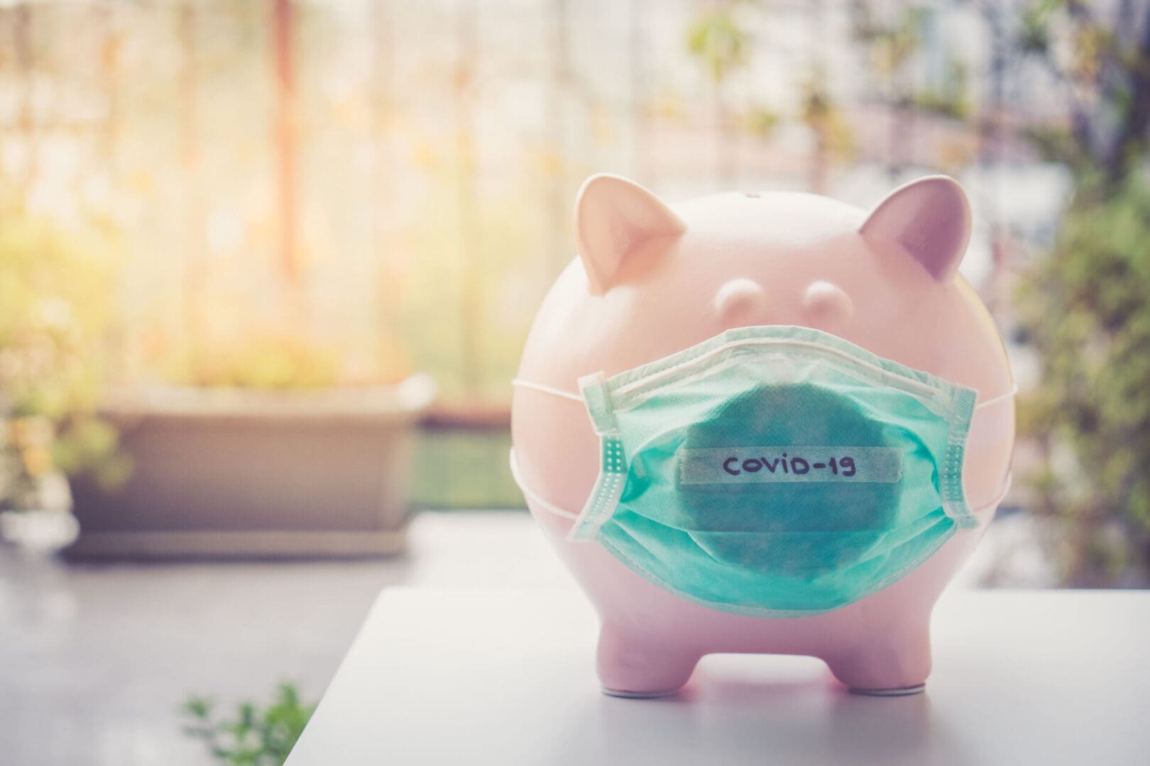 A piggy bank with a face mask on it.