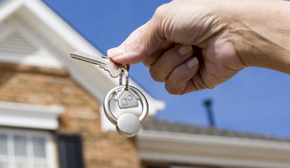 A person holding keys to their new home.