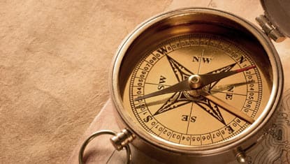 A close up of the compass on top of a table