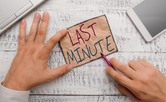 A person holding a piece of paper that says " last minute ".