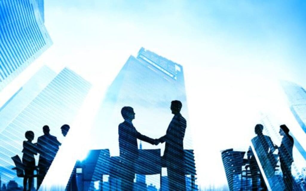 Two men shaking hands in front of a city skyline.