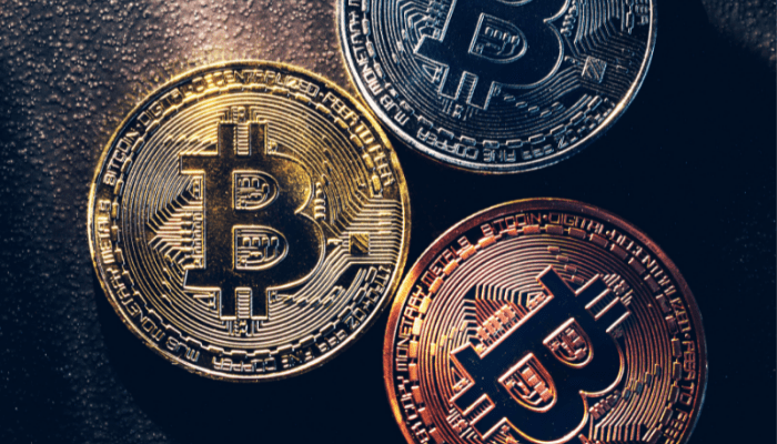 Three different colored coins sitting on top of a table.