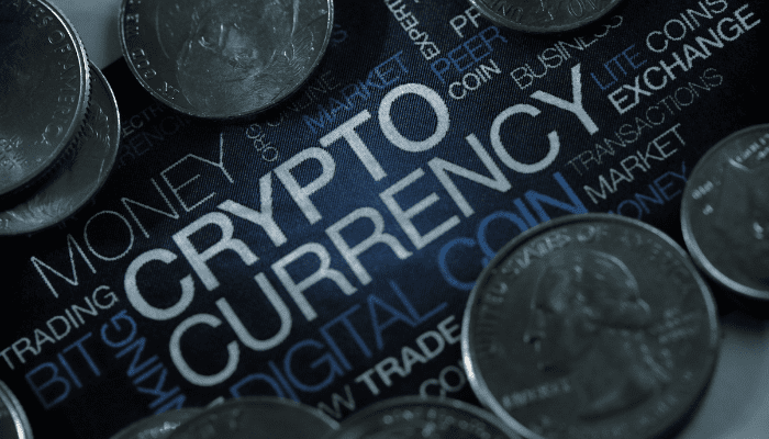 A close up of some coins on top of the word " crypto currency ".