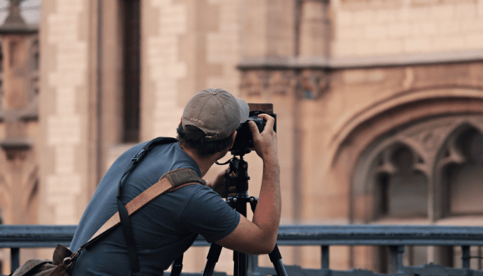 A man taking pictures of an old building.