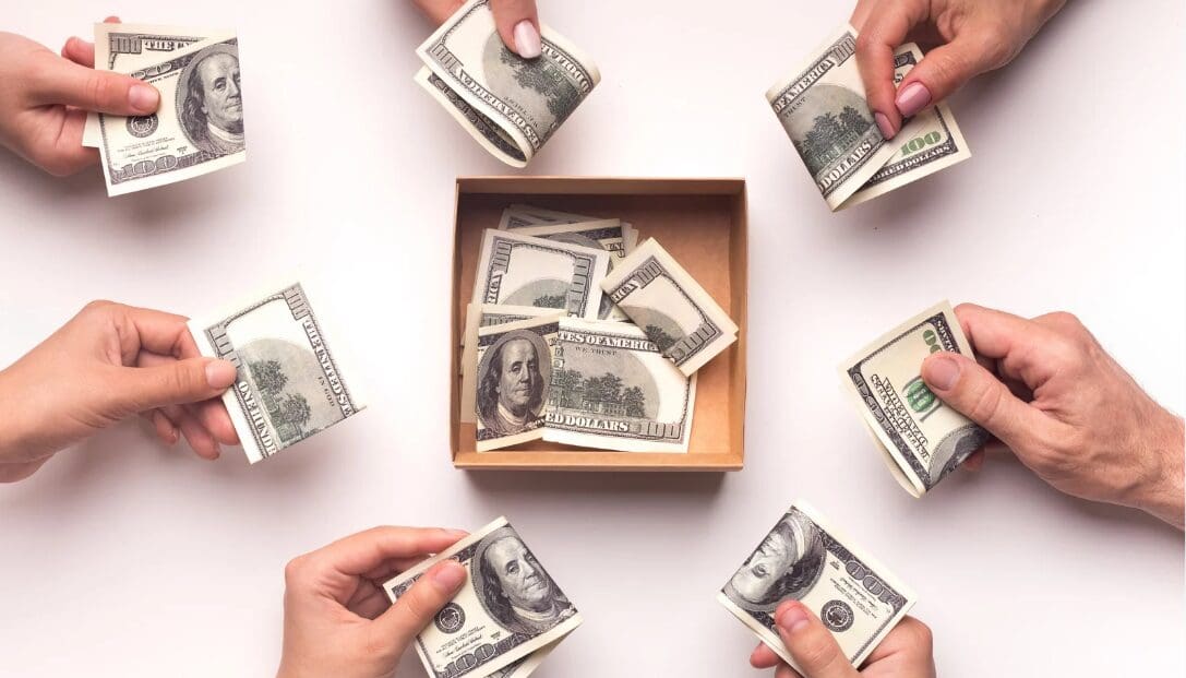 A box of money is being held by hands.