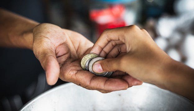 A person holding two coins in their hands.