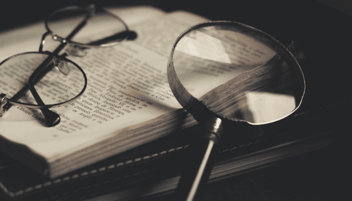Magnifying glass and glasses on a book.