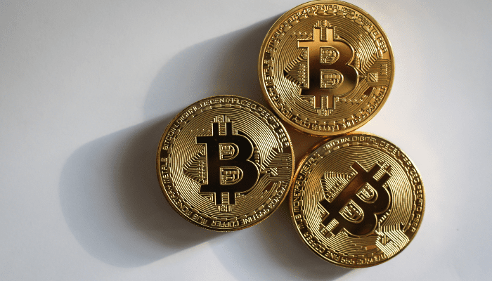 Three gold Bitcoin cryptocurrency coins.